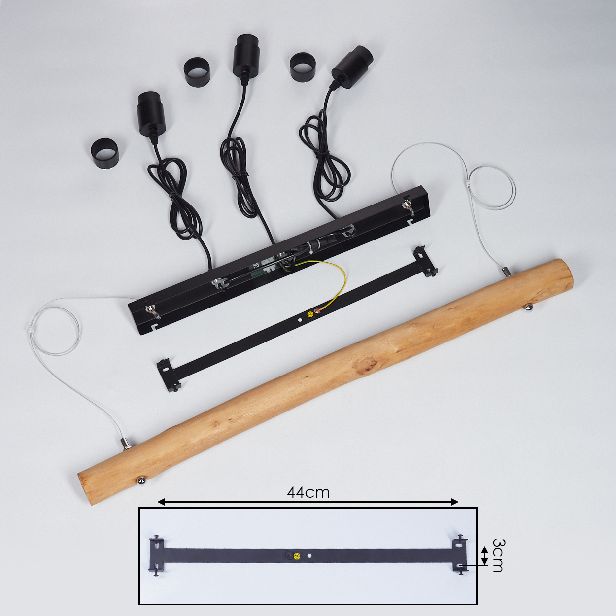 Zerlegte Lampenkomponenten: Holzbalken, schwarze Metallteile, Fassungen, Drähte und eine Diagramm mit den Maßen: 44 cm und 3 cm.