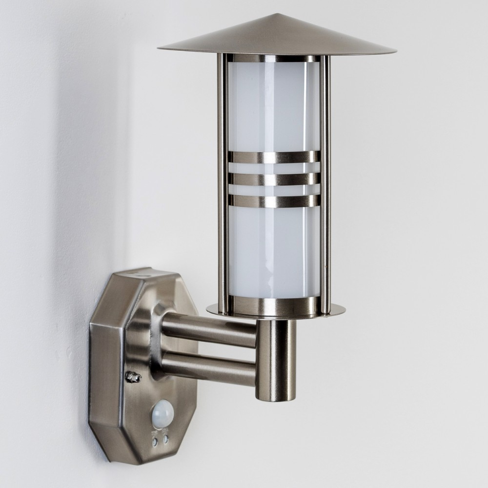 Eine metallische Wandleuchte mit zylindrischem Licht und Sensor. Sie ist an einer weißen Wand montiert.