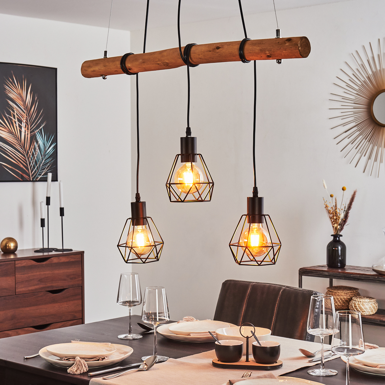 Esszimmer mit Holzbalken-Beleuchtung. Tisch gedeckt, mit Tellern, Gläsern und einem Mittelstück. Braune Möbel im Hintergrund.