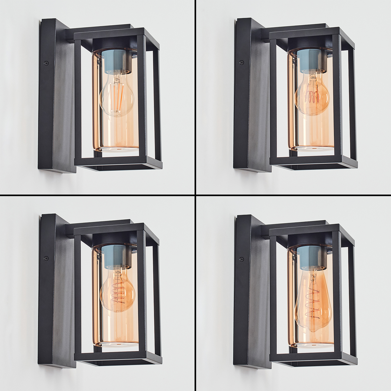 Vier schwarze Wandleuchten mit bernsteinfarbenem Glas und Edison-Glühbirnen sind an einer weißen Wand montiert.