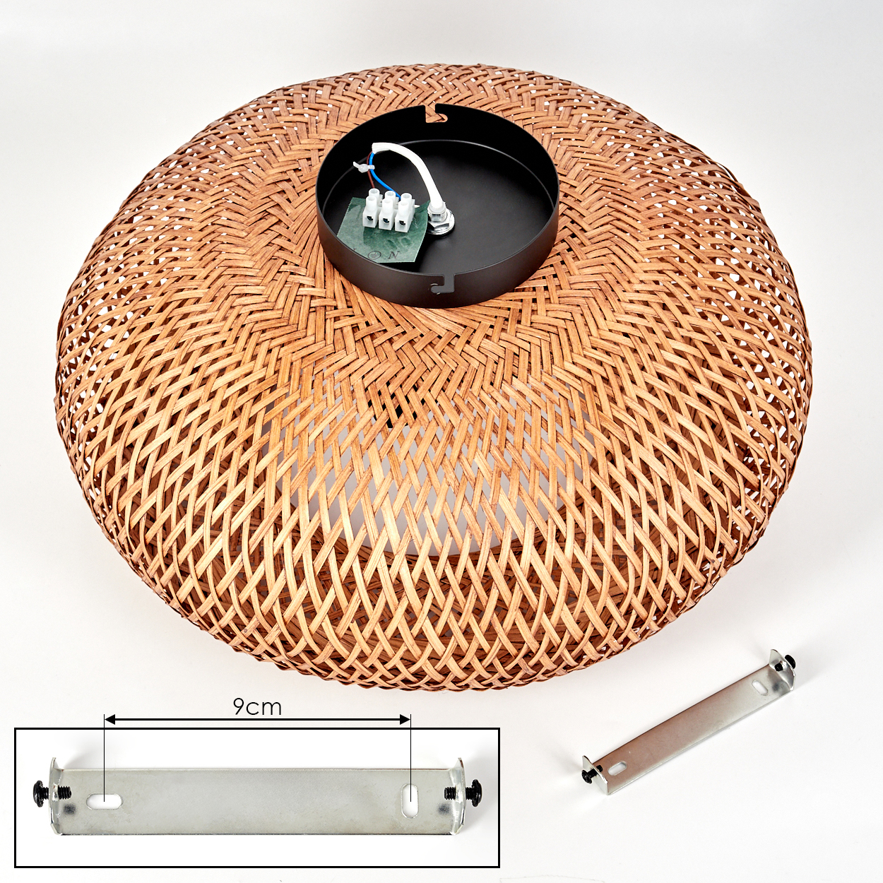 Gewebter Rattan-Lampenschirm mit schwarzem Metallaufsatz, Verkabelung und Halterung. Zusätzliche Halterung sichtbar. Weißer Hintergrund.