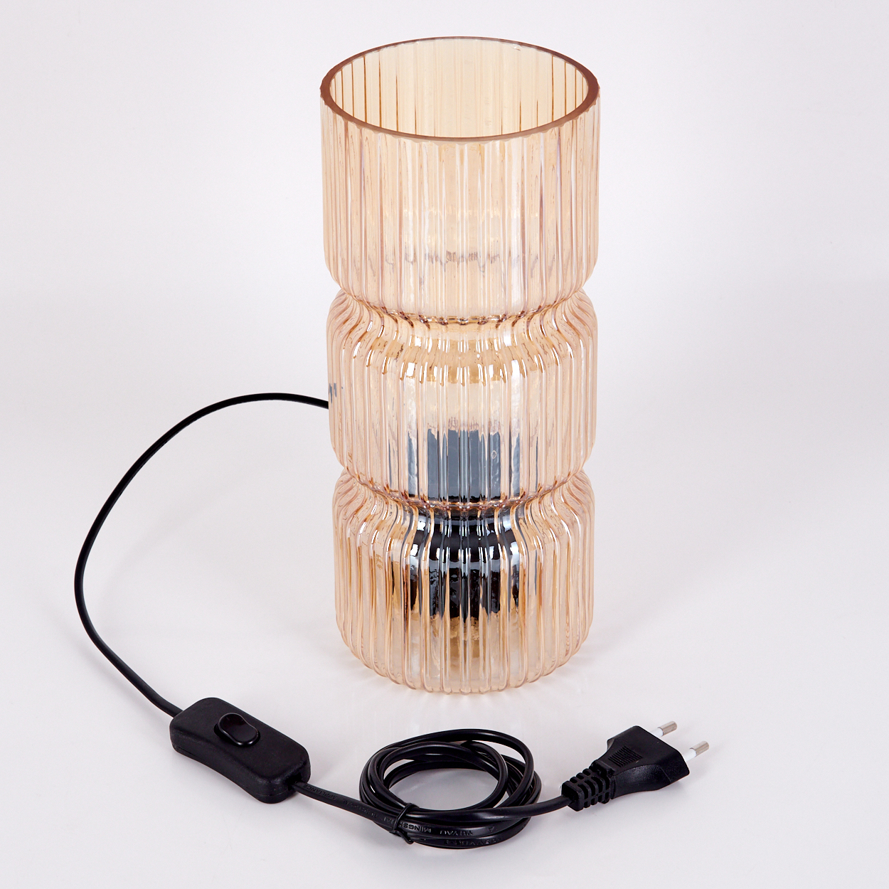 Eine dreistufige, pfirsichfarbene Glaslampe mit schwarzem Kabel, Schalter und Stecker auf weißem Hintergrund.