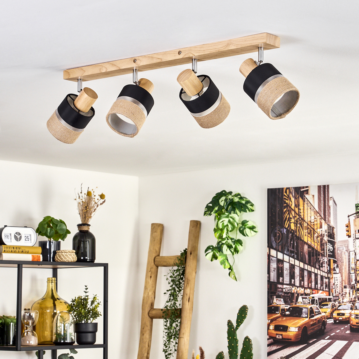 Deckenleuchte mit vier Strahlern, schwarz-beige Schirme. Im Hintergrund ein Regal mit Deko und ein New York City Bild.