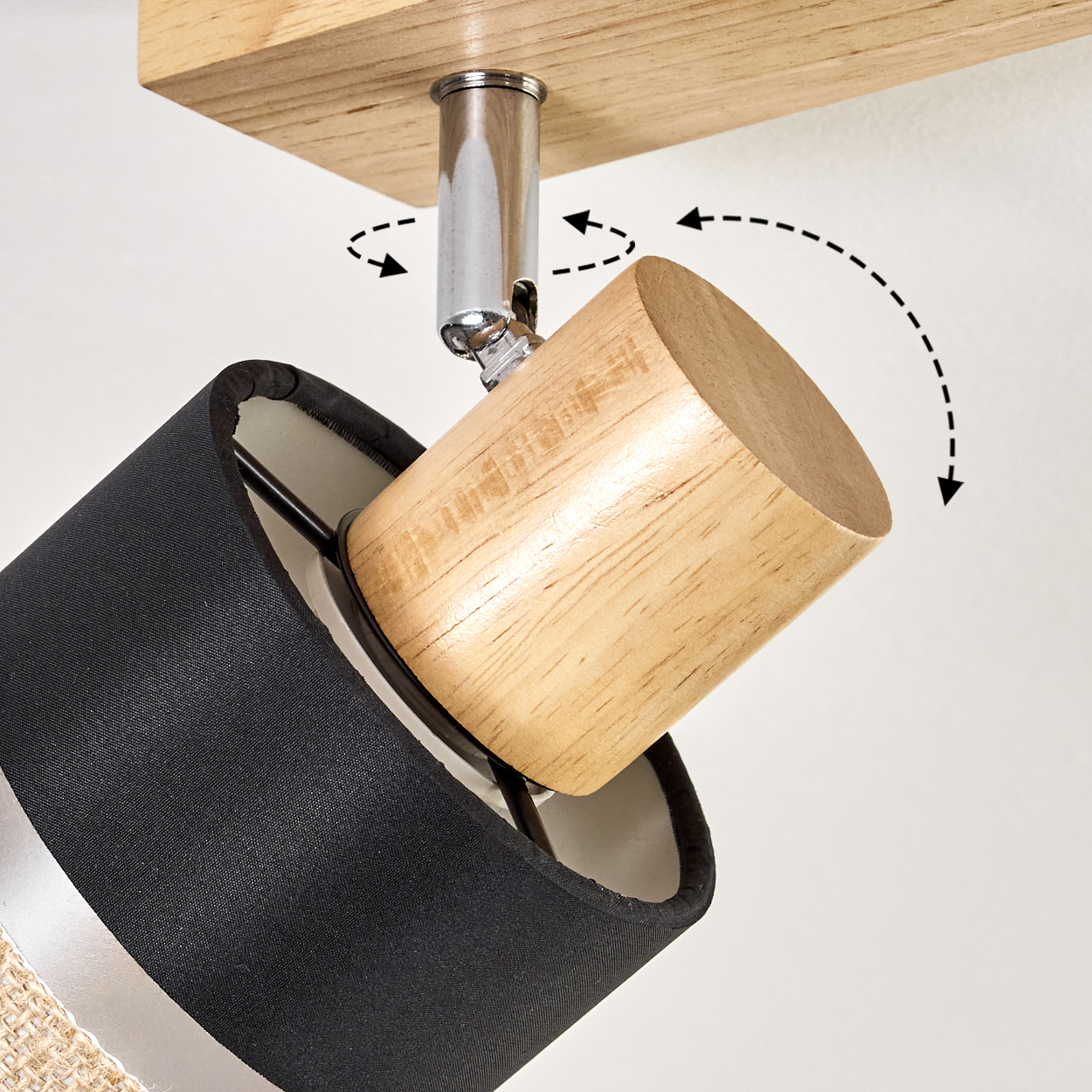 Eine Lampe mit schwarzem Schirm und Holzakzent ist an einem Holzbrett befestigt. Pfeile weisen auf die Verstellbarkeit hin.