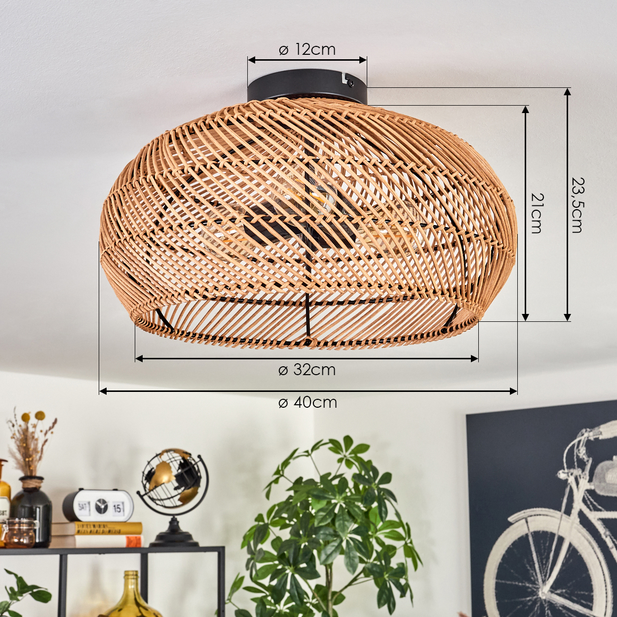 Ein Lampenschirm aus Korbgeflecht ist an der Decke montiert, mit Maßangaben. Im Vordergrund sind Pflanzen und Dekorationsartikel auf einem Regal.