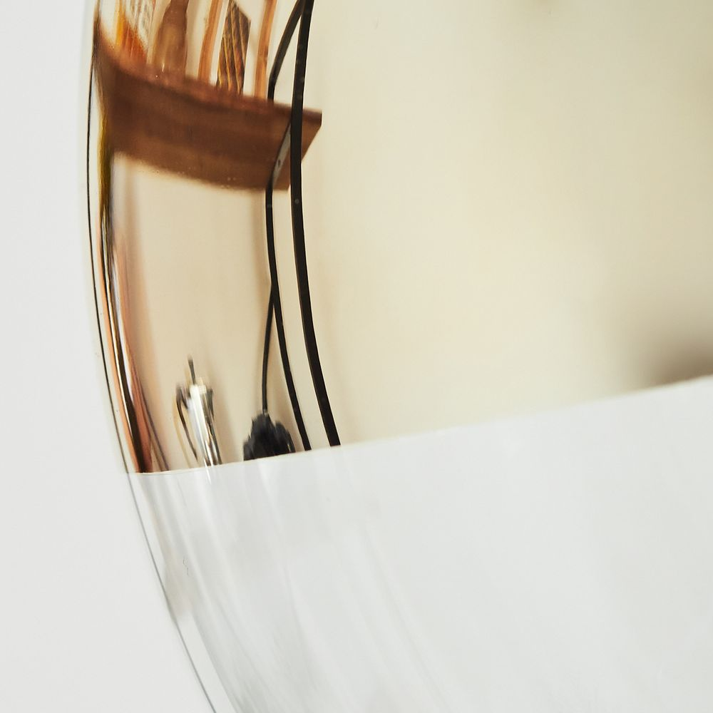 Nahaufnahme einer glänzenden, gebogenen Oberfläche, die ein Regal, Gegenstände und schwarze Kabel vor weißem und beigem Hintergrund reflektiert.
