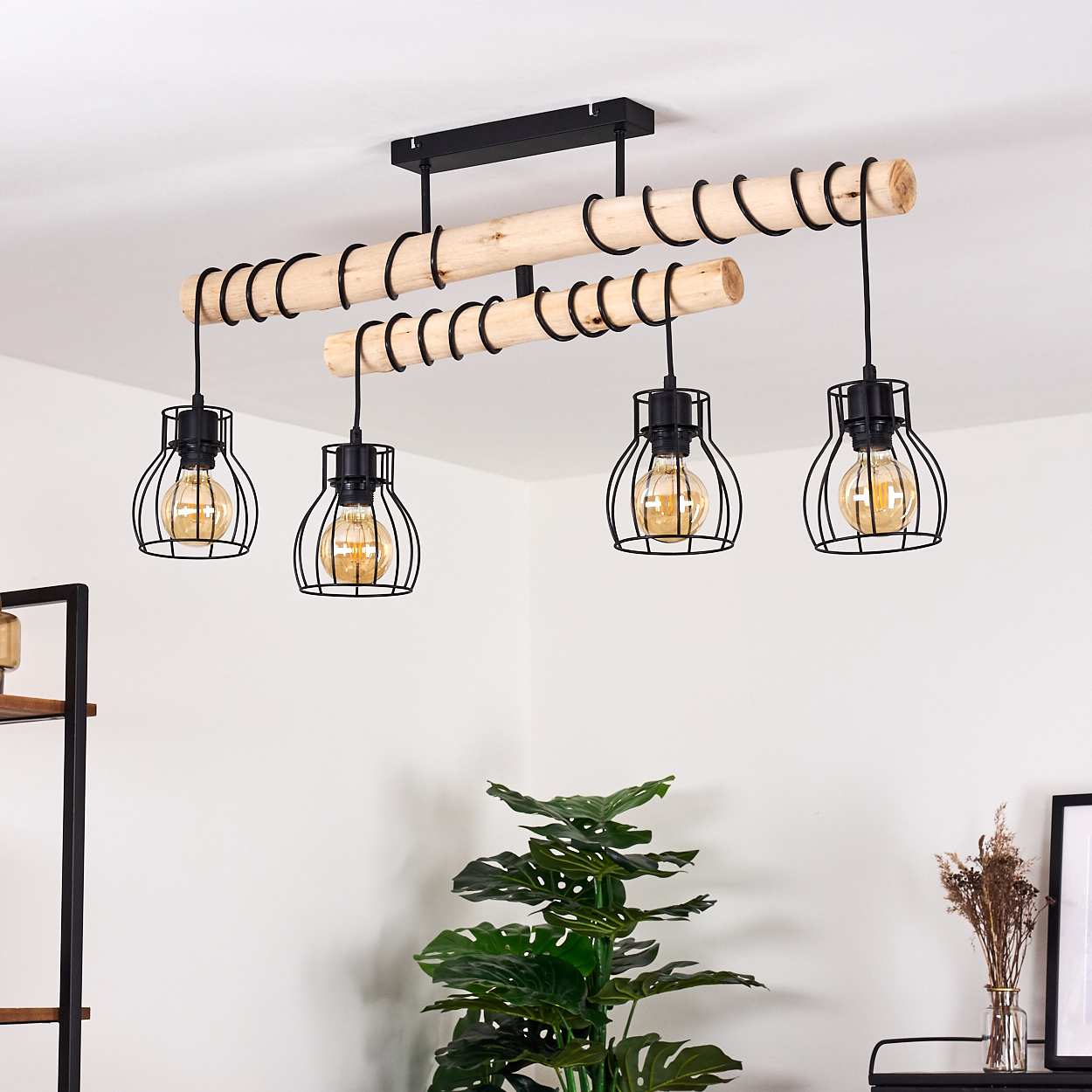 Eine moderne Deckenleuchte mit vier Käfiglichtern hängt von der Decke. Holzbalken und schwarze Metallakzente werden verwendet.