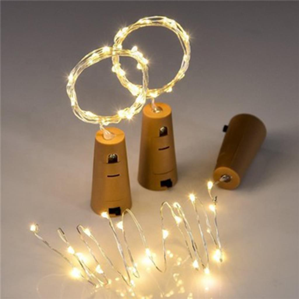 Drei korkförmige Lichter mit beleuchteten Drahtkreisen. Eines ist separat. Warme, weiche Beleuchtung auf weißer Oberfläche.