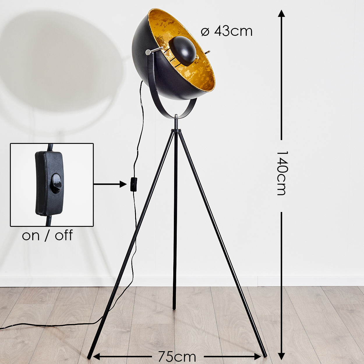 Eine schwarz-goldene Stehlampe auf einem Stativfuß mit einem Schalter mit der Aufschrift 'ein/aus'. Maße: 140 cm hoch, 75 cm breit und 43 cm Durchmesser.