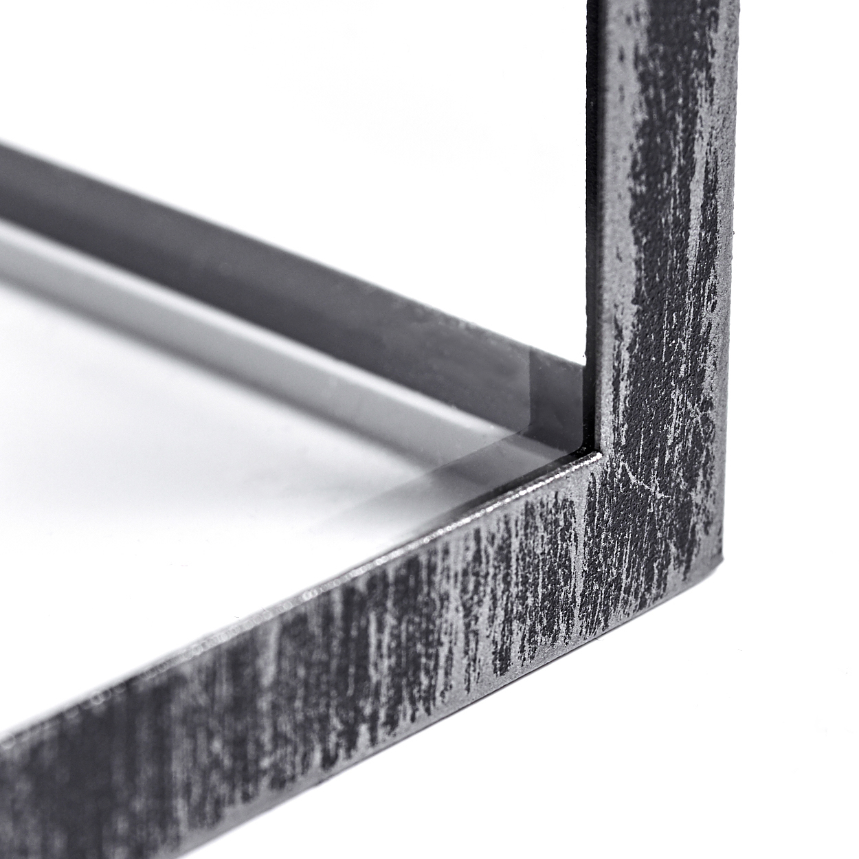 Nahaufnahme einer Metallecke. Der Rahmen ist grau mit strukturierter Oberfläche. Der Hintergrund ist weiß.