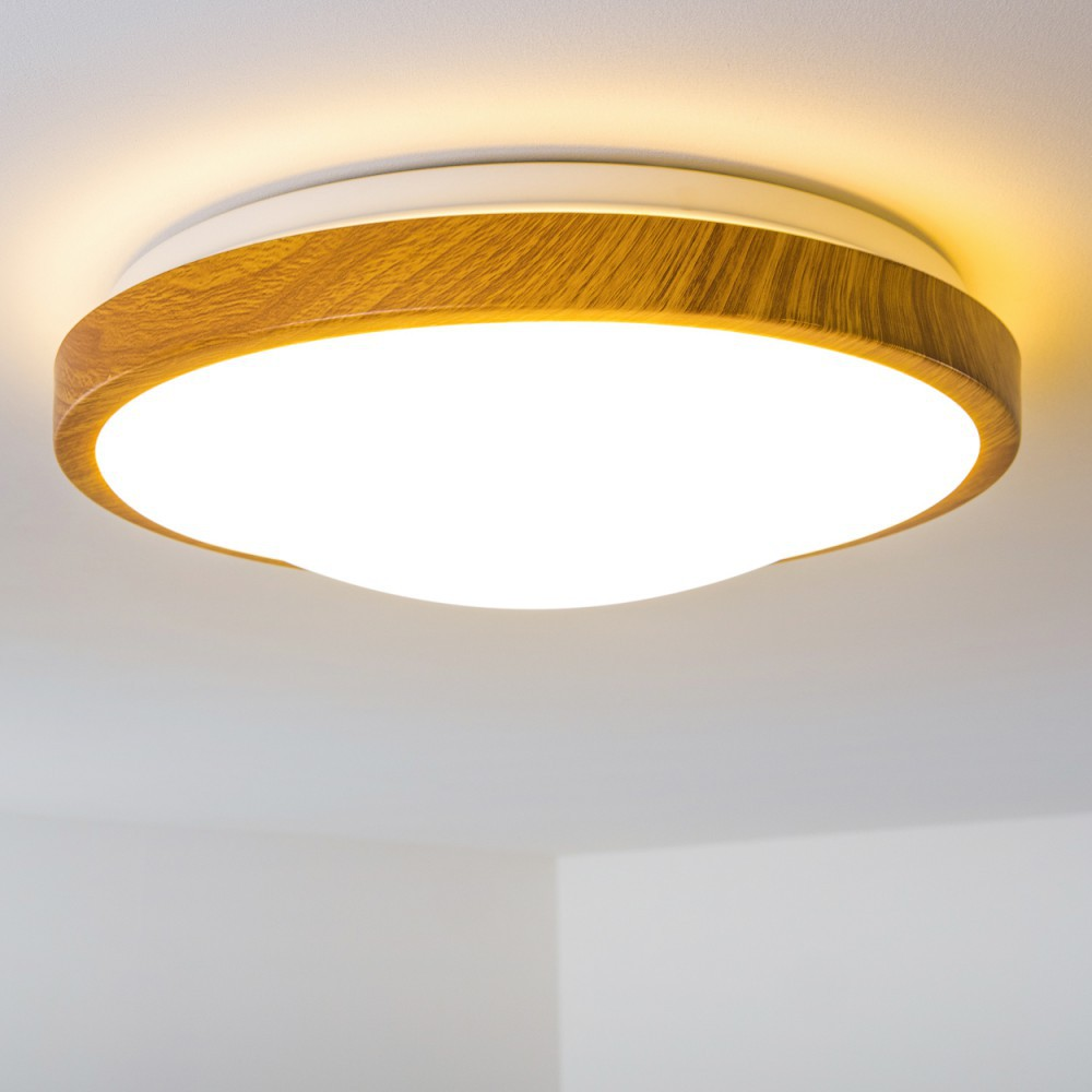 Eine moderne Deckenleuchte mit Holzverkleidung und hellem, weißem, abgerundetem Licht. Der Hintergrund ist eine weiße Decke.