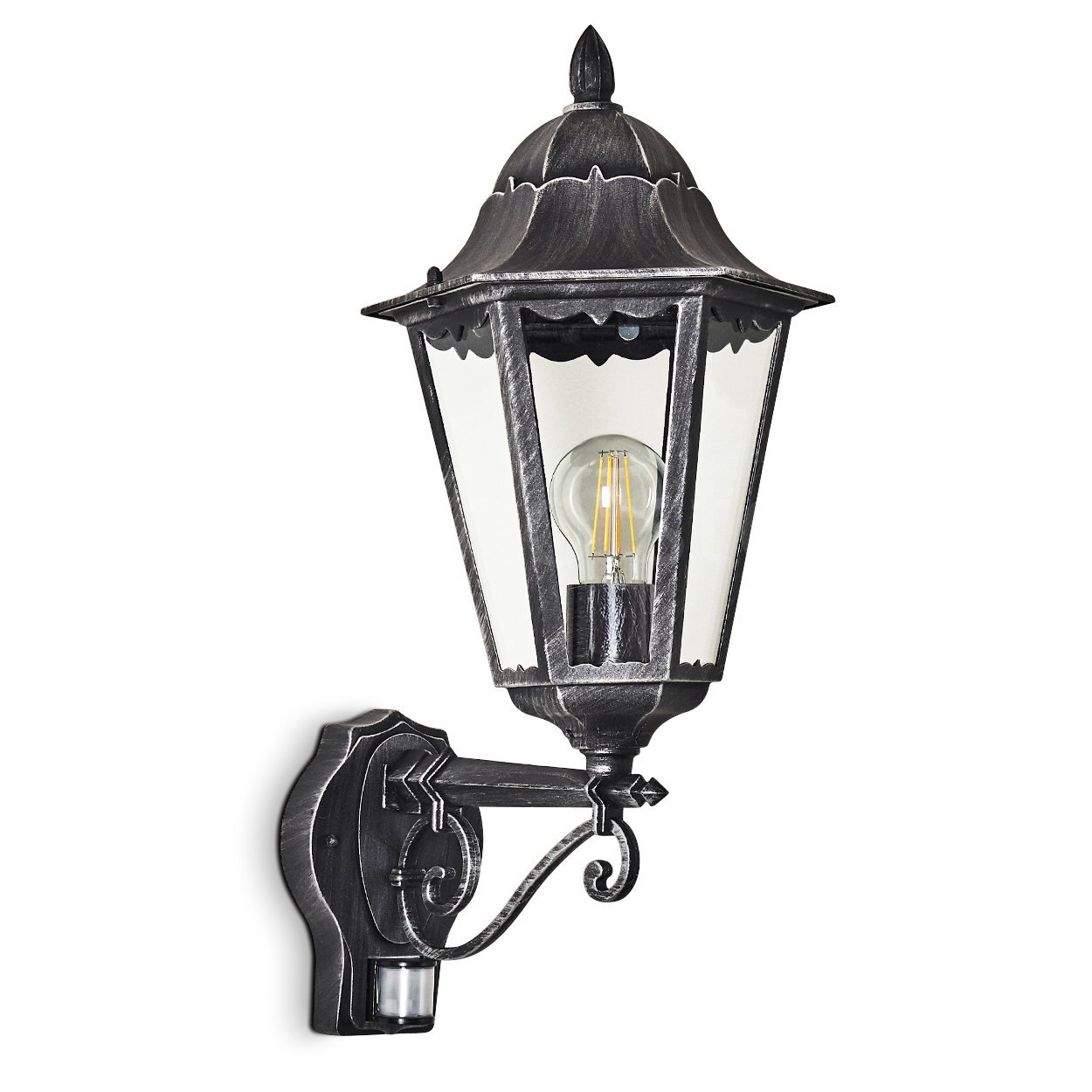 Eine an der Wand befestigte, metallisch-graue Außenlampe mit einem Glasgehäuse und einer Glühbirne im Inneren, montiert an einer weißen Wand.