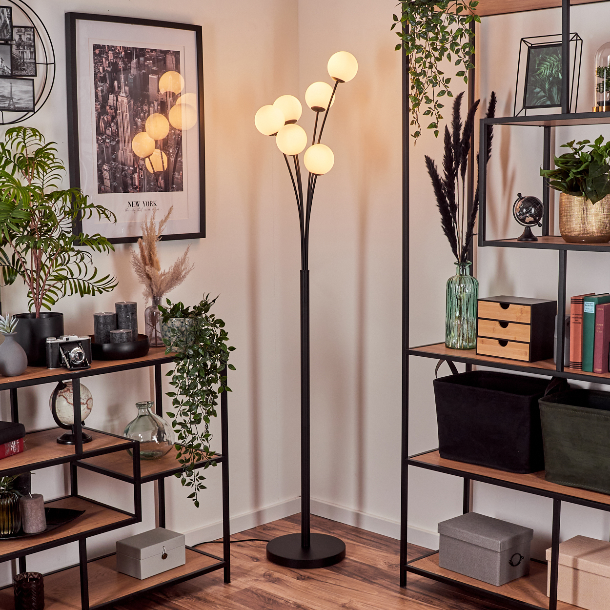 Eine Zimmerecke mit Stehlampe, Regalen mit Pflanzen und Deko sowie einem New York Stadtbild.