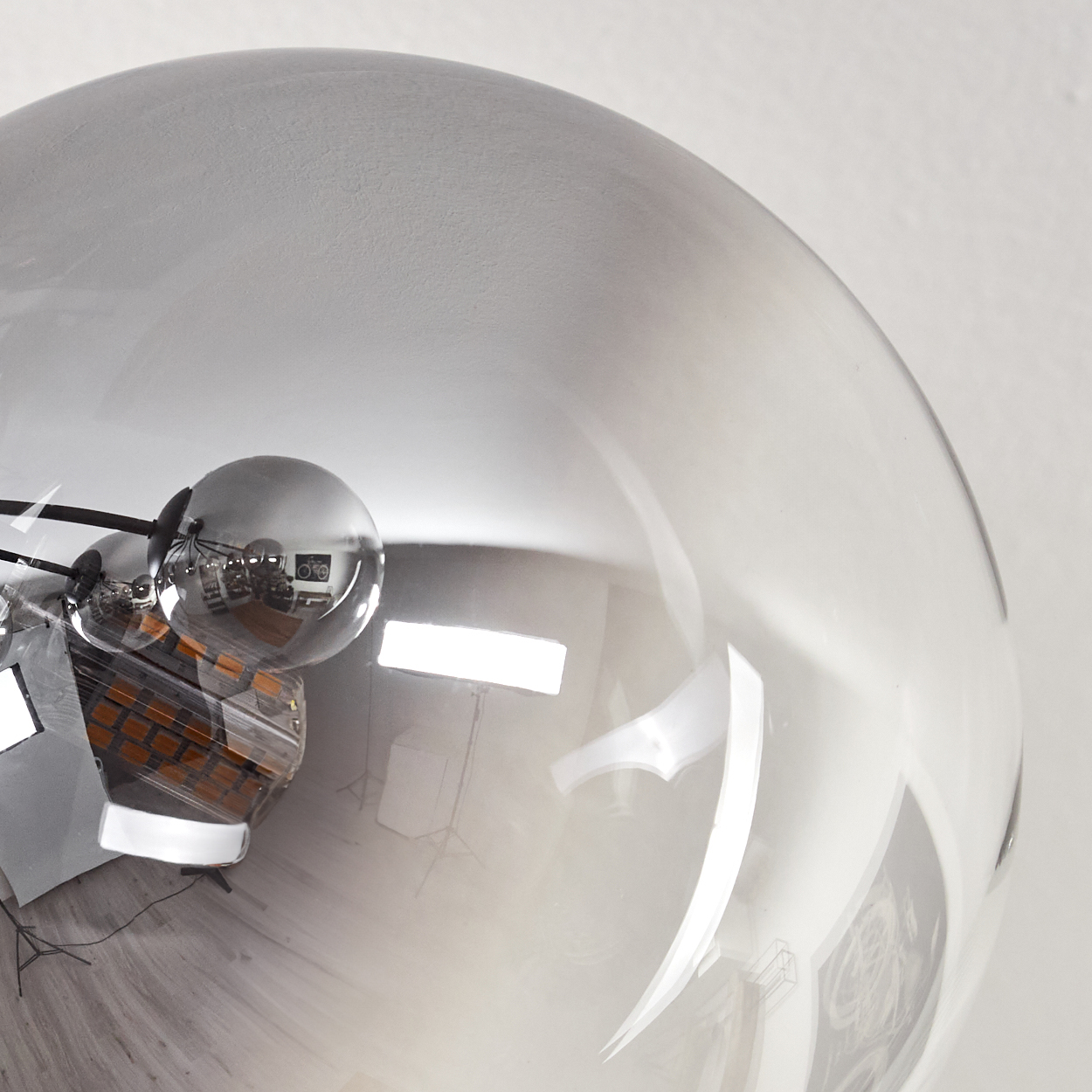 Eine große, klare Kugel reflektiert einen Raum. Innen sind Lichter und Objekte zu sehen, zusammen mit der Einrichtung.