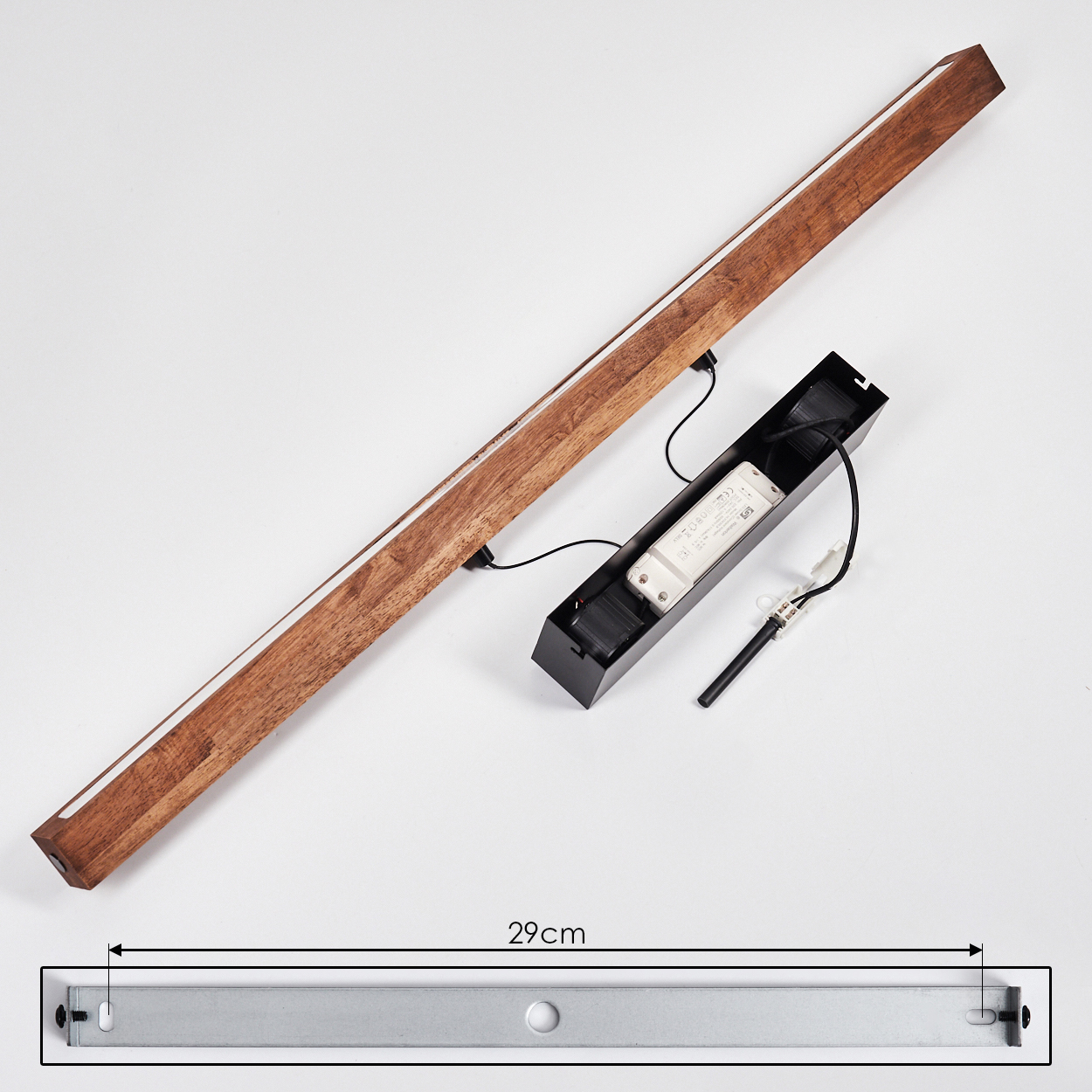 Eine Holzleuchte mit einem weißen Lichtstreifen, eine schwarze Box mit elektronischen Bauteilen und eine Metallhalterung.