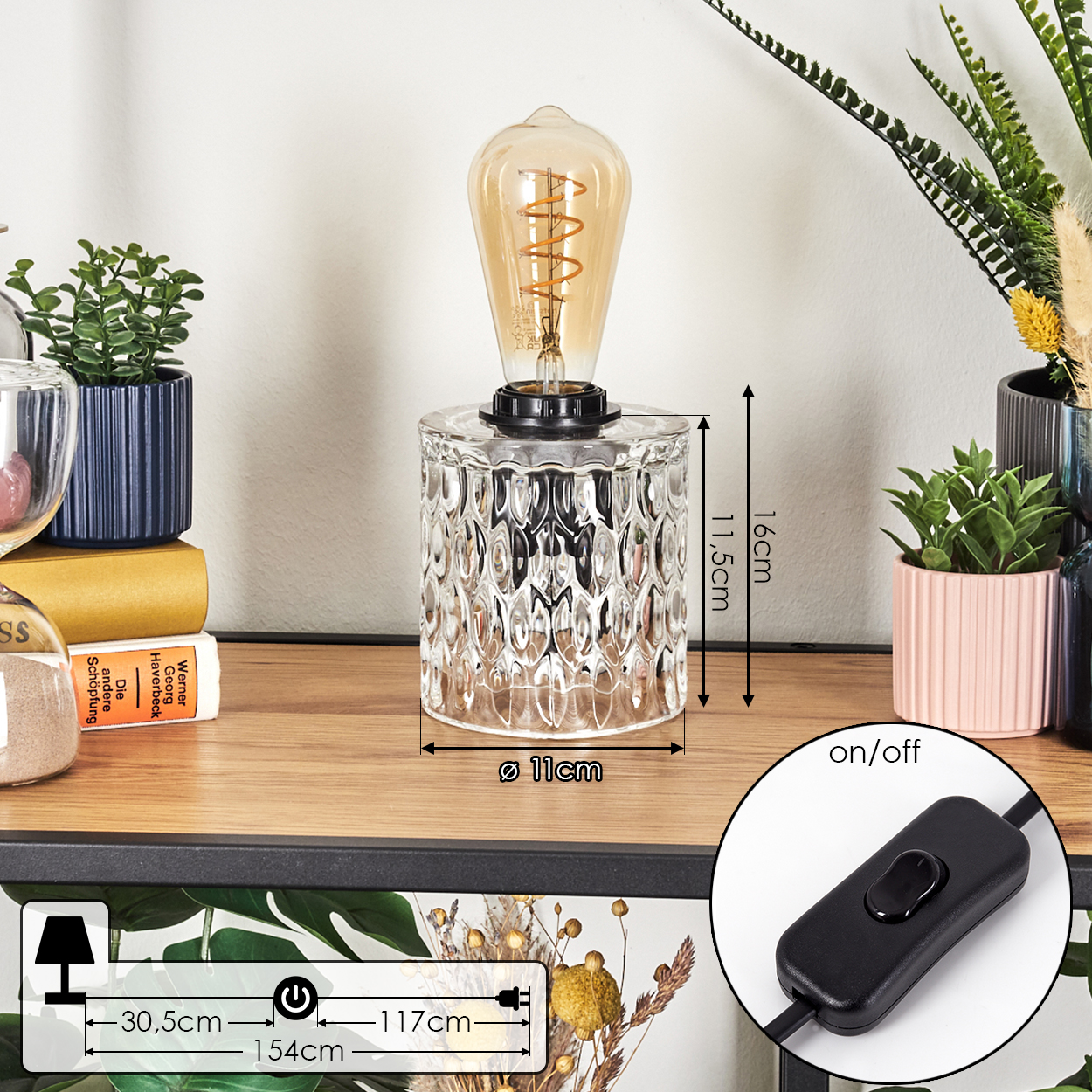 Eine dekorative Lampe mit Glasfuß und sichtbarer Glühbirne. Abmessungen werden angezeigt. Ein-/Ausschalter ist sichtbar.