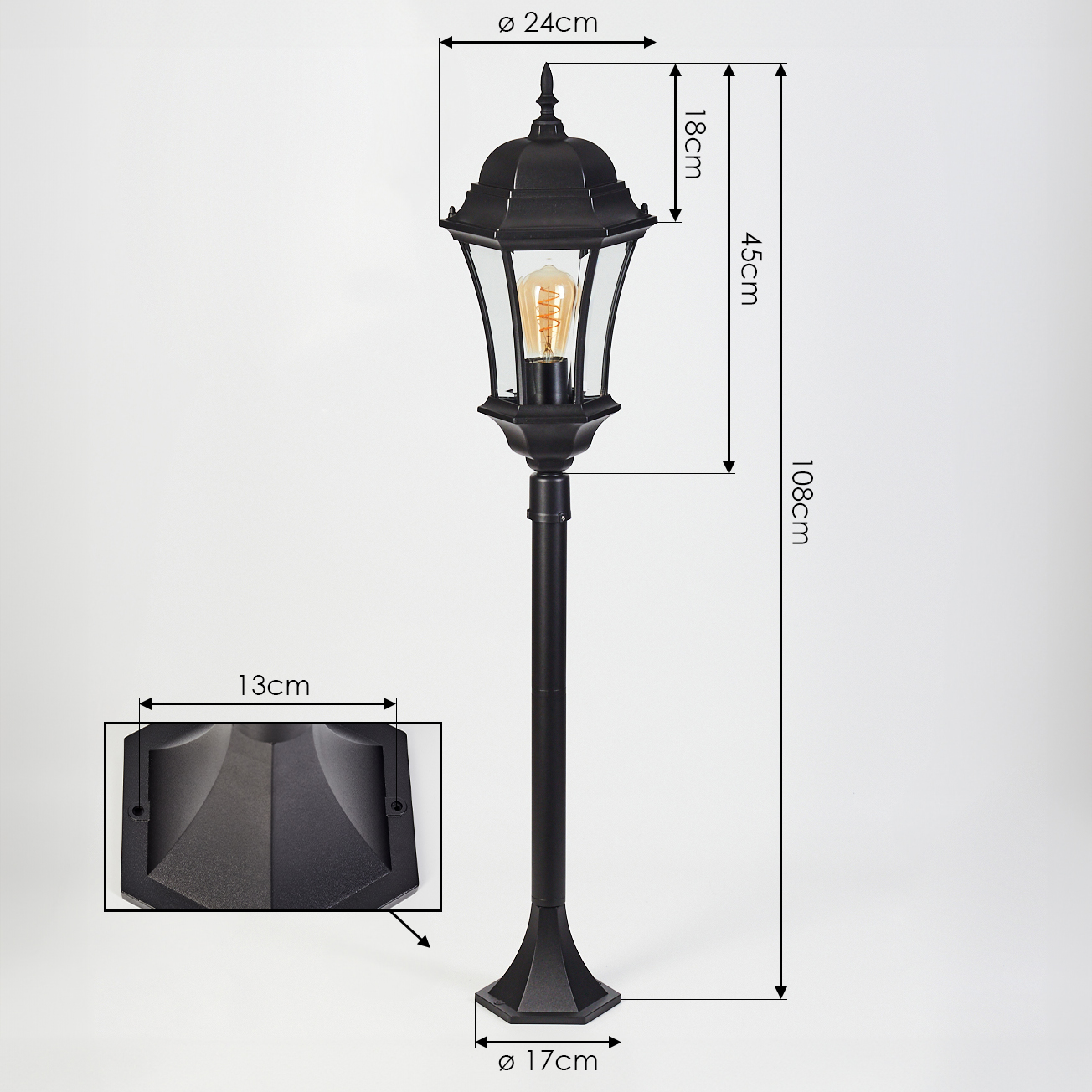 Schwarze Außenlampe mit angegebenen Abmessungen. Sie hat eine dekorative Oberseite, Glasscheiben, eine Glühbirne und einen Sockel.