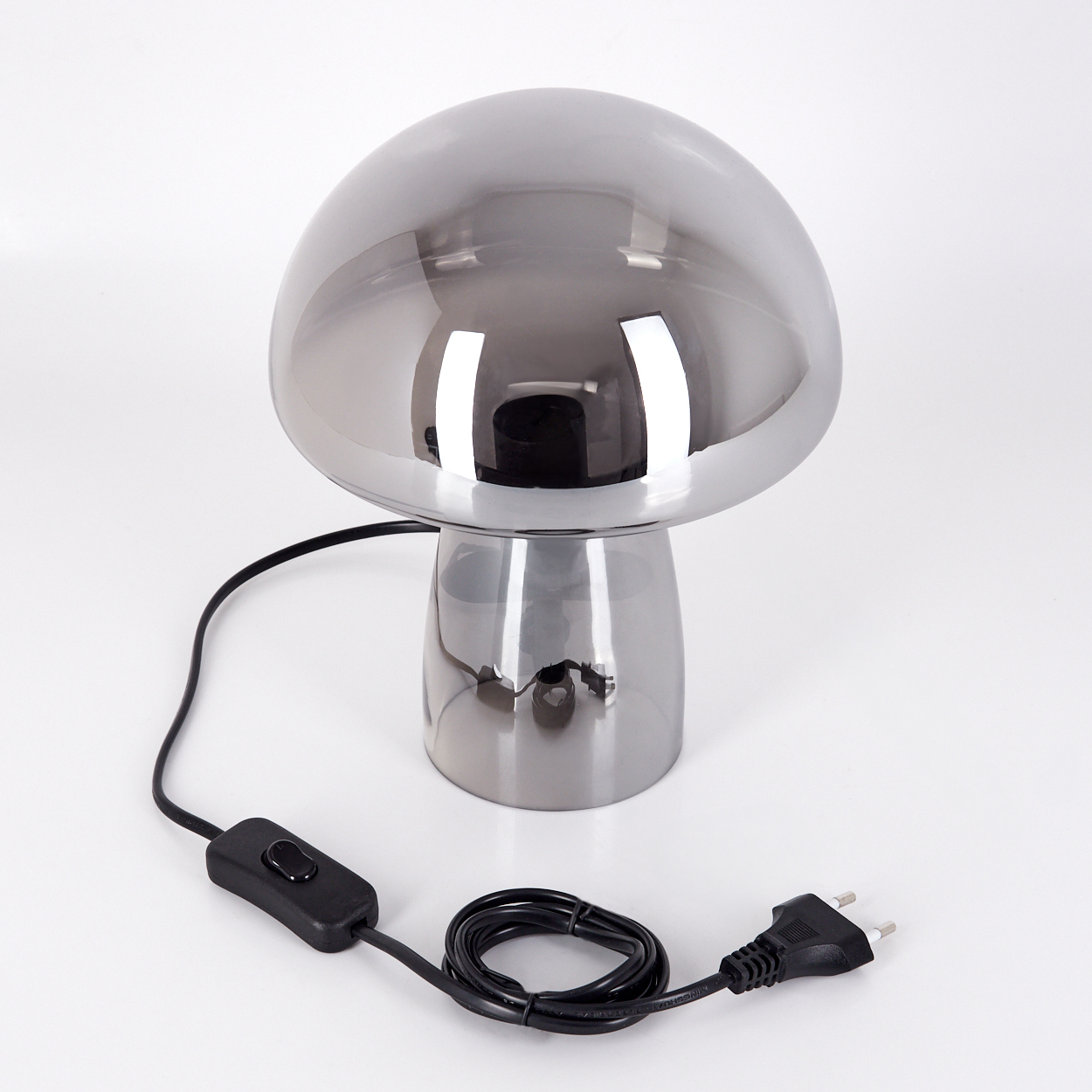 Eine pilzförmige Lampe mit Chromoberfläche, einem schwarzen Netzkabel und einem Schalter auf weißem Untergrund.