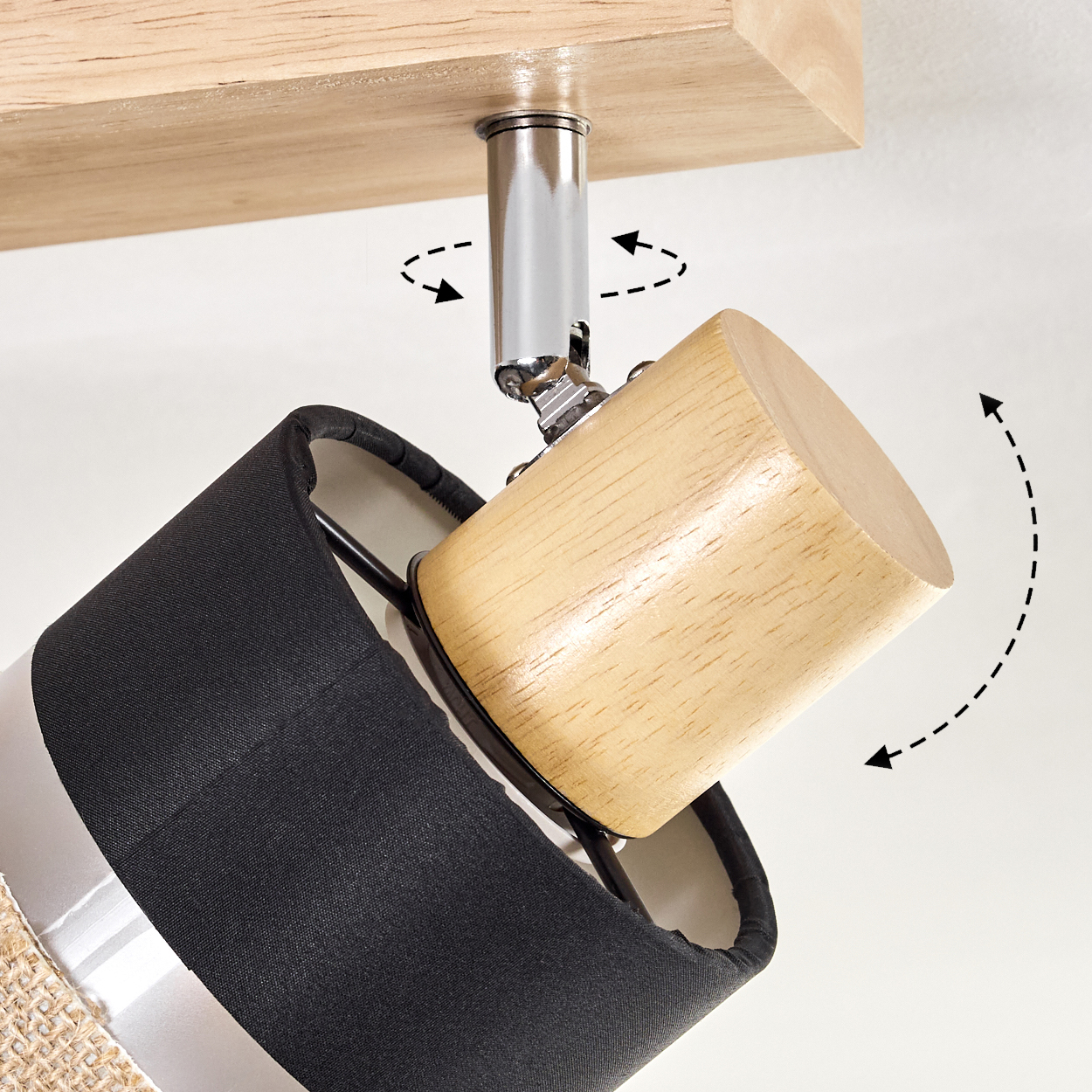 Eine Lampe mit schwarzem Schirm und Holzakzenten. Die Lampe ist an einem Holzbalken befestigt, mit Pfeilen, die Drehbewegungen anzeigen.