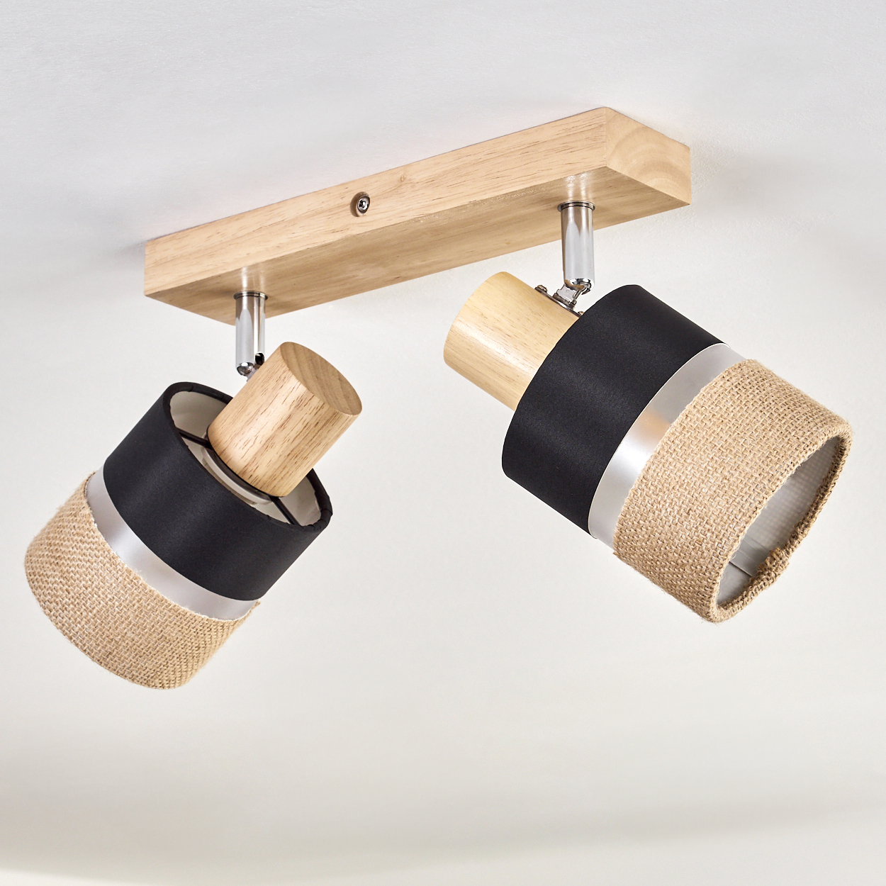 Deckenleuchte mit zwei verstellbaren Strahlern. Merkmale Holz- und Schwarzakzente, mit Jute-Schirmen. Auf einem Holzsockel montiert.