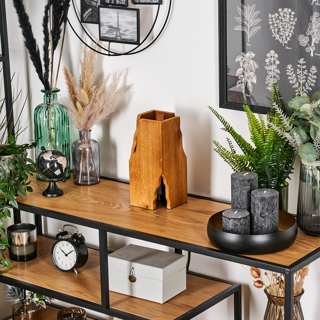 Ein Holzregal mit Dekoration. Enthält Vasen, Kerzen, einen Globus, eine Uhr, eine Kiste und eine Holzskulptur.