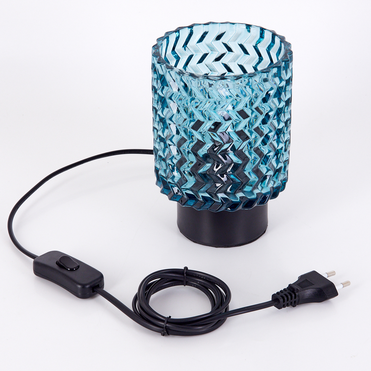 Eine blaue Glaslampe mit schwarzem Sockel, Kabel und Schalter. Die Lampe steht auf einer weißen Oberfläche.