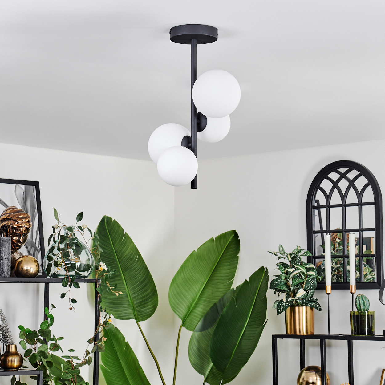 Ein Zimmer mit Pflanzen, Regalen und einem schwarzen Kronleuchter mit weißen Kugellampen. Ein Bogenfenster und Dekorationen sind im Hintergrund.