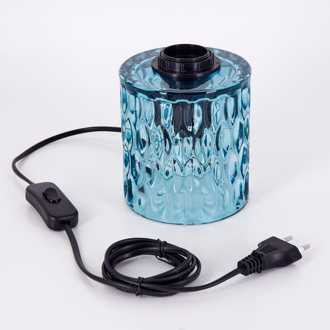 Eine blaue Glaslampe mit schwarzem Sockel und Draht, Schalter und Stecker auf Weiß. Strukturiertes Glas. Schwarzes Kabel.