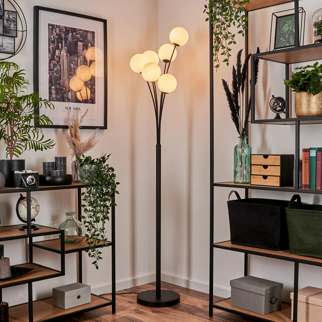 Innenraum mit schwarzer Stehlampe mit Kugellichtern, Regalen mit Dekorationen und einem gerahmten New York City-Druck.
