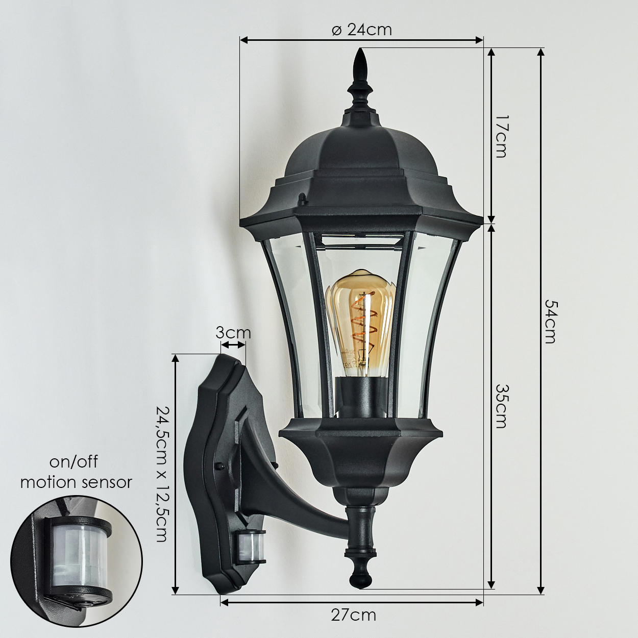 Schwarze Außenwandleuchte mit Bewegungsmelder. Merkmale: Glaspaneele, Glühbirne und Abmessungen in Zentimetern an einer weißen Wand.