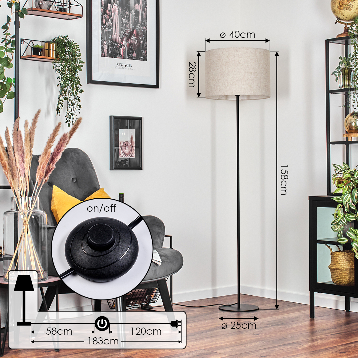 Eine Stehlampe mit beigem Lampenschirm und schwarzem Ständer. Die Lampe steht neben einem grauen Sessel und vor einer weißen Wand mit Bildern.