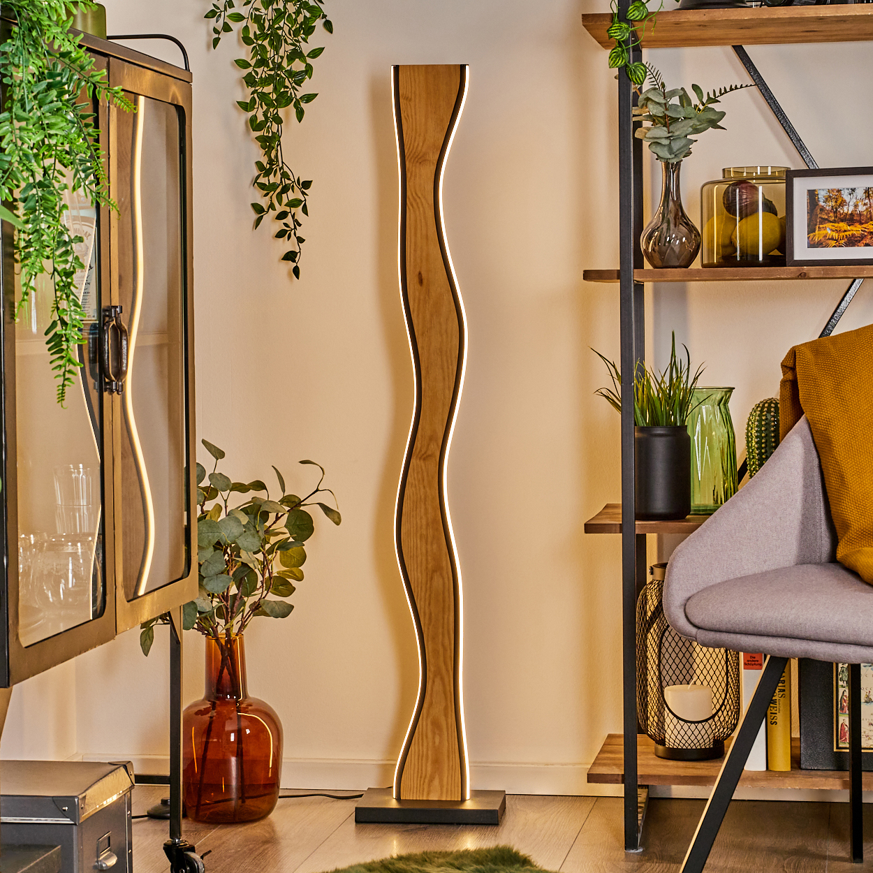 Ein modernes Wohnzimmer mit einer wellenförmigen Holzlampe. Es gibt einen Schrank mit Pflanzen und Regale mit Dekoration, in der Nähe eines Stuhls und Holzbodens.