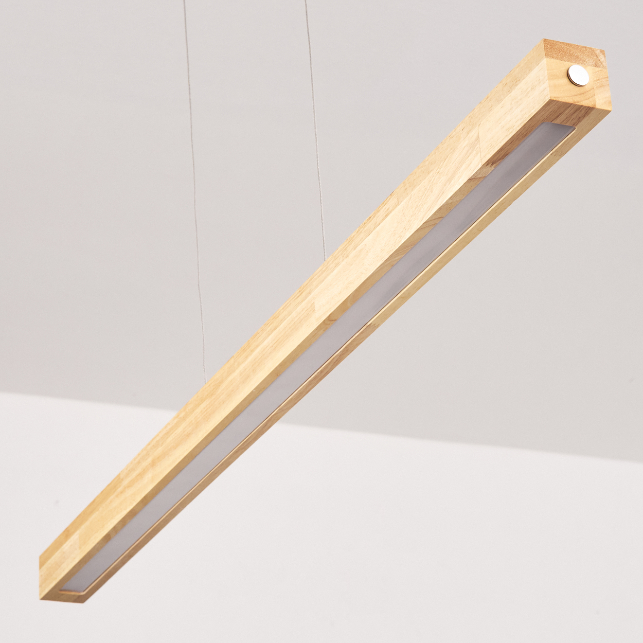 Eine rechteckige Holzleuchte hängt an dünnen Drähten vor weißem Hintergrund. Das Licht ist aus.