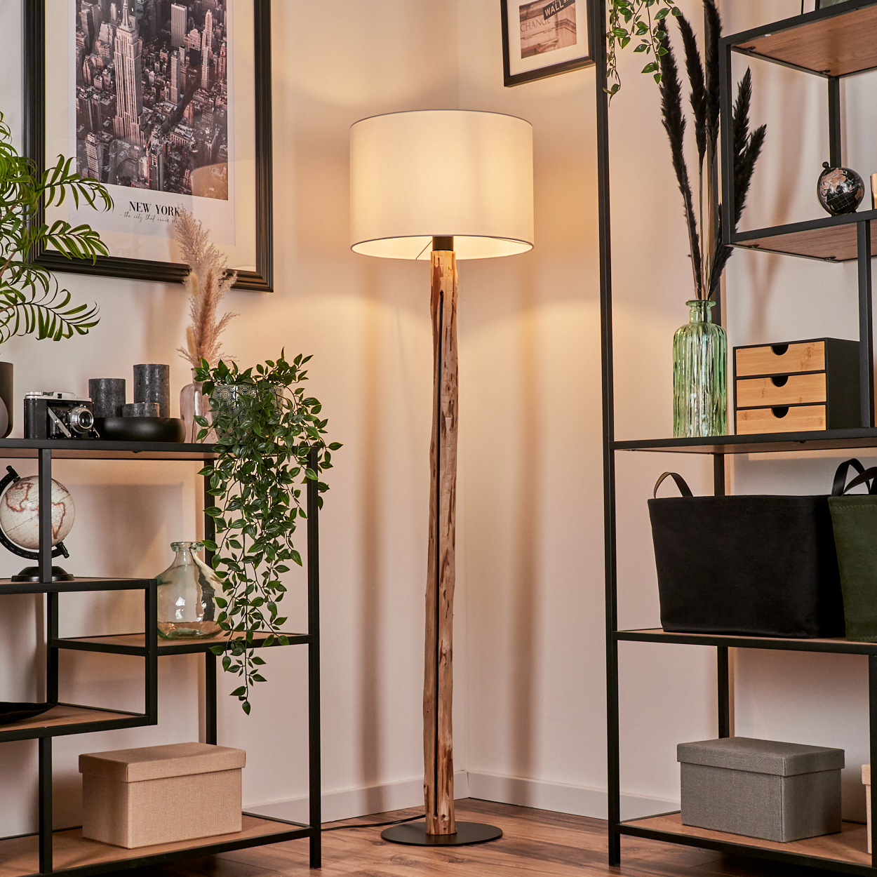 Raumecke mit Stehlampe, Regalen mit Dekorationen, Pflanzen und einem New York-Bild.