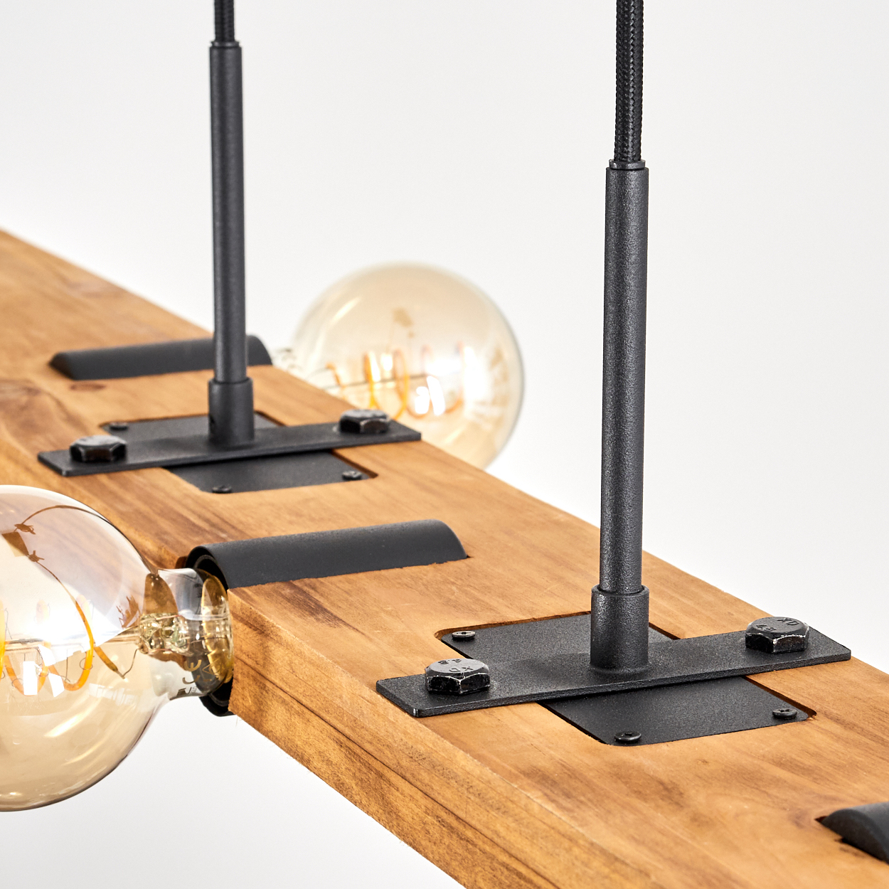 Holzbalken mit drei Glühbirnen, schwarzen Metallstützen und weißem Hintergrund. Die Glühbirnen leuchten und das Holz ist braun.