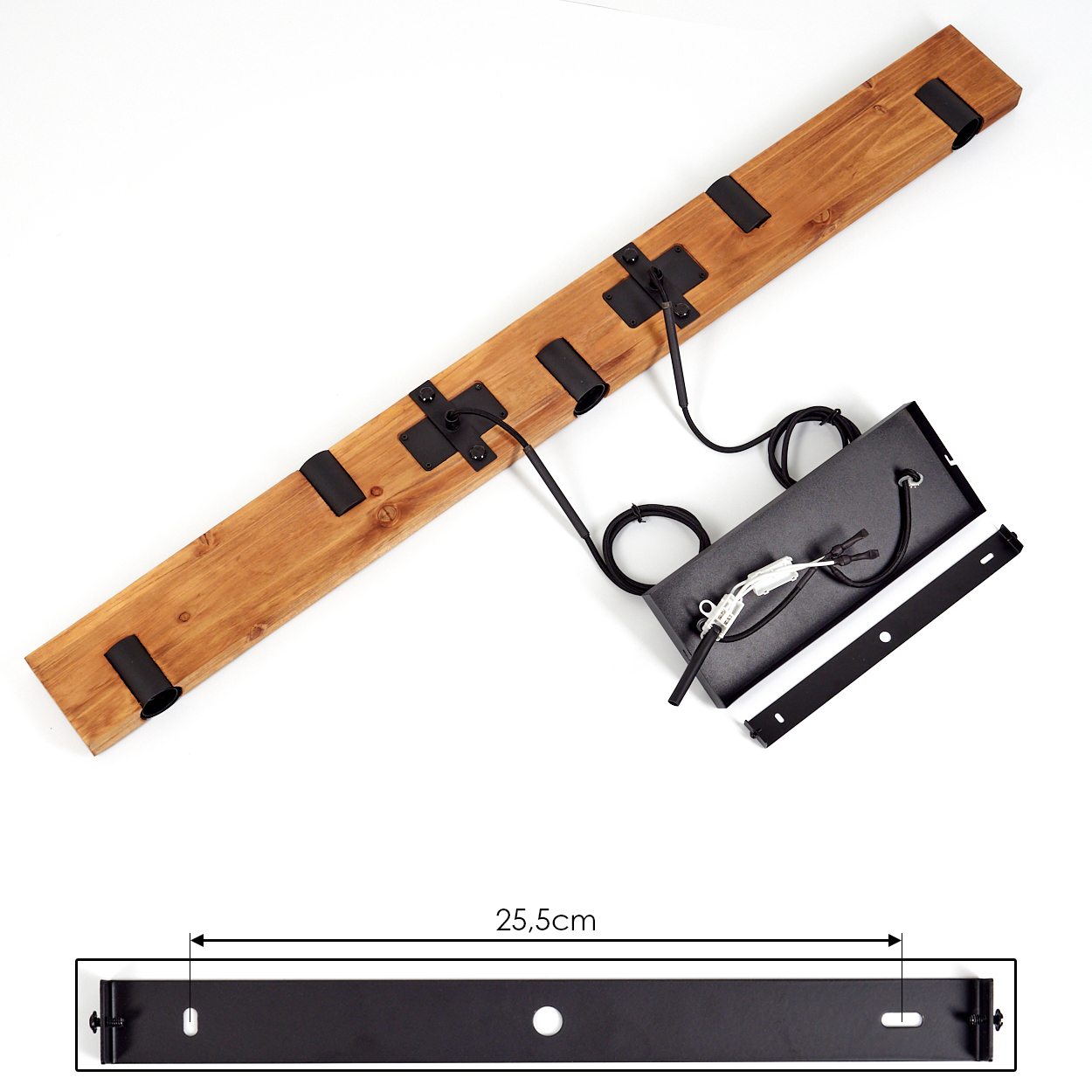 Holzbalken mit schwarzen Metallbeschlägen und Drähten. Darunter eine rechteckige Metallplatte mit 25,5 cm Messung und eine schwarze Box.