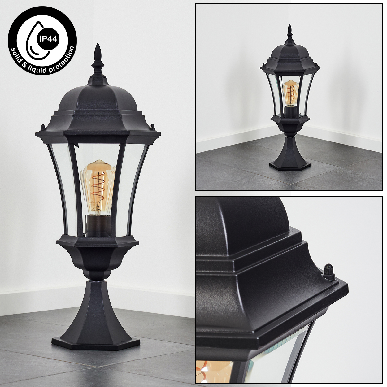 Schwarze Außenlampe mit Glasgehäuse und dekorativer Glühbirne. Sie steht auf einem Fliesenboden. Die Lampe ist für Feststoff- und Flüssigkeitsschutz.