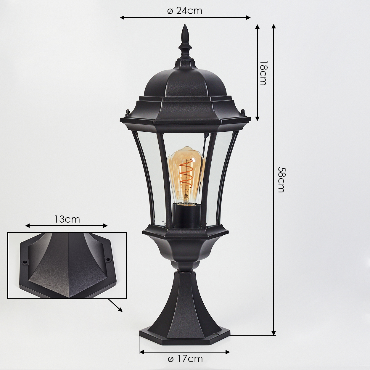 Schwarze Außenlampe mit angegebenen Abmessungen. Sie hat ein Glasgehäuse mit einer Vintage-Glühbirne und steht auf einem Sockel. Abmessungen sind angegeben.