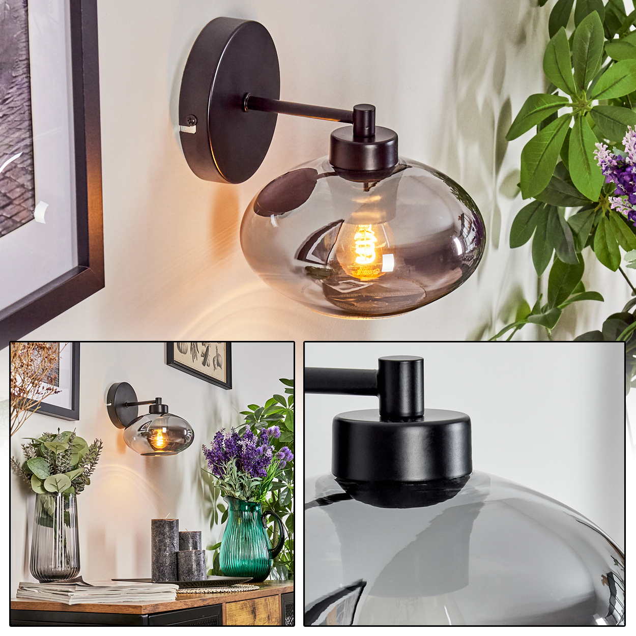 Eine Wandlampe mit dunklem Rahmen und transparentem Glasschirm. Dahinter Pflanzen mit grünen Blättern und lila Blüten.