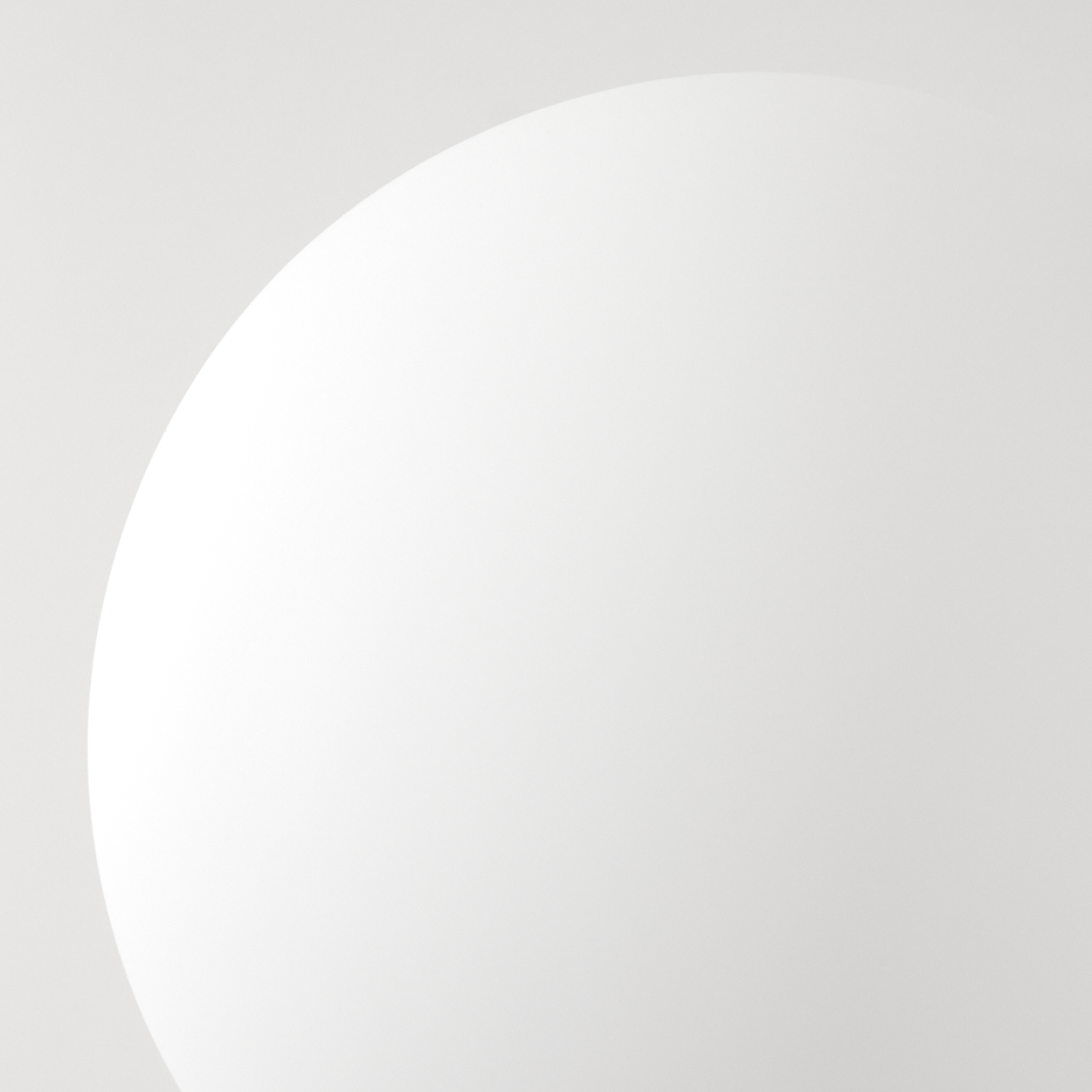 Eine weiße, gebogene Form links vor grauem Hintergrund. Die Kante der Kurve ist sauber und deutlich.