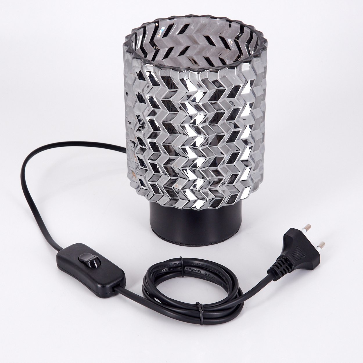 Eine silber-schwarze Lampe mit geometrischem Muster, verbunden mit einem schwarzen Netzkabel, Schalter und Stecker, alles auf weißem Hintergrund.