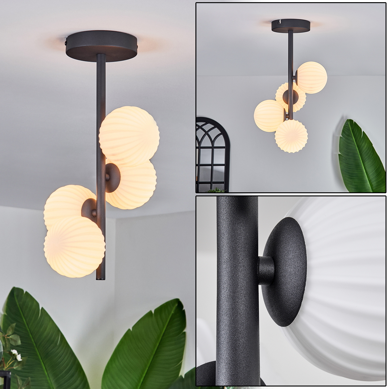 Eine moderne schwarze Deckenlampe mit vier weißen Kugelleuchten. Eine Pflanze befindet sich im Vordergrund.
