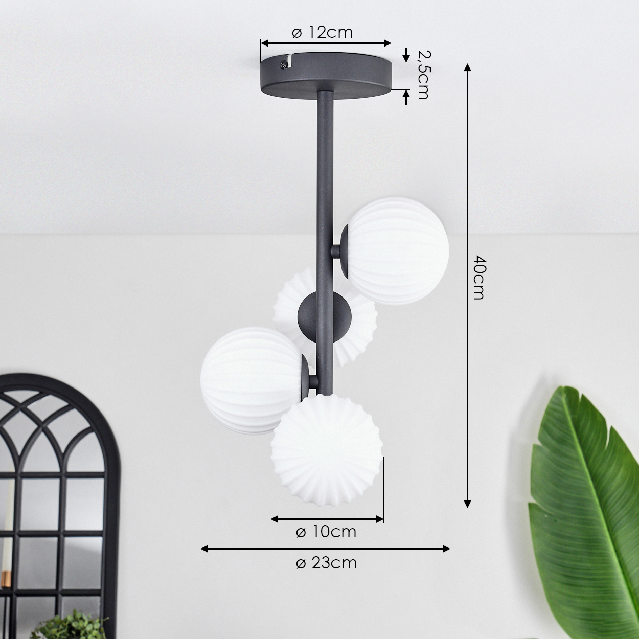 Eine schwarz-weiße Deckenleuchte. Sie hat drei weiße kugelförmige Lampen. Abmessungen: 12cm, 2,5cm, 40cm, 10cm und 23cm.