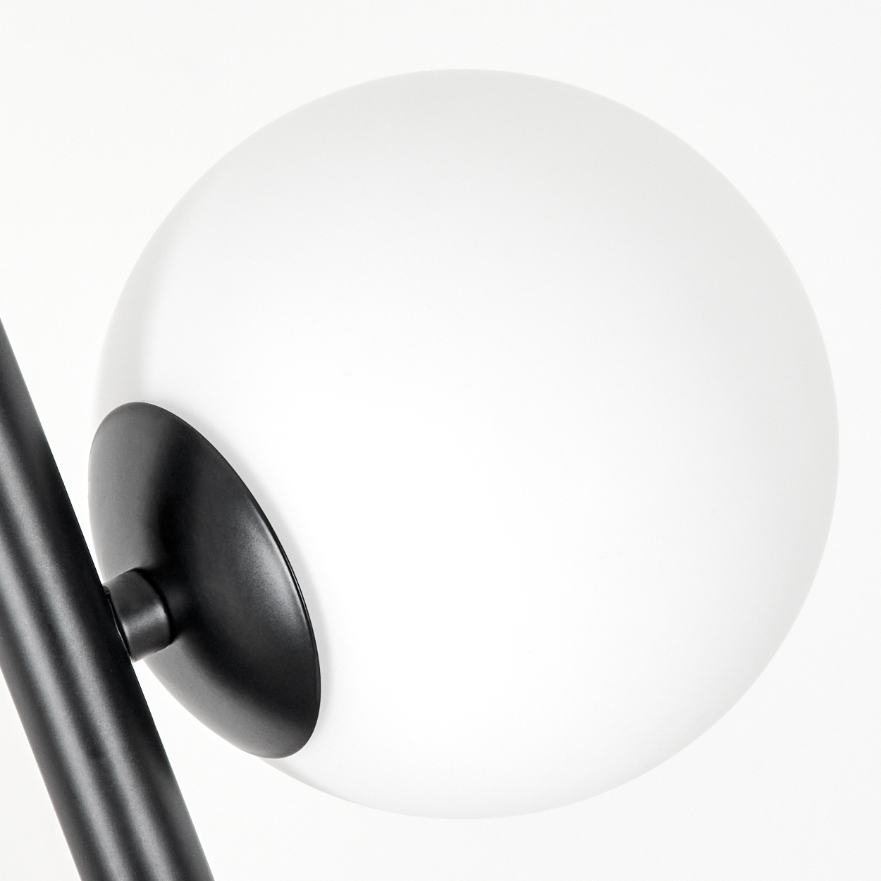 Eine moderne Lampe mit großem weißen Globus und schwarzem Metallträger. Vor schlichtem weißen Hintergrund, der das Design zeigt.