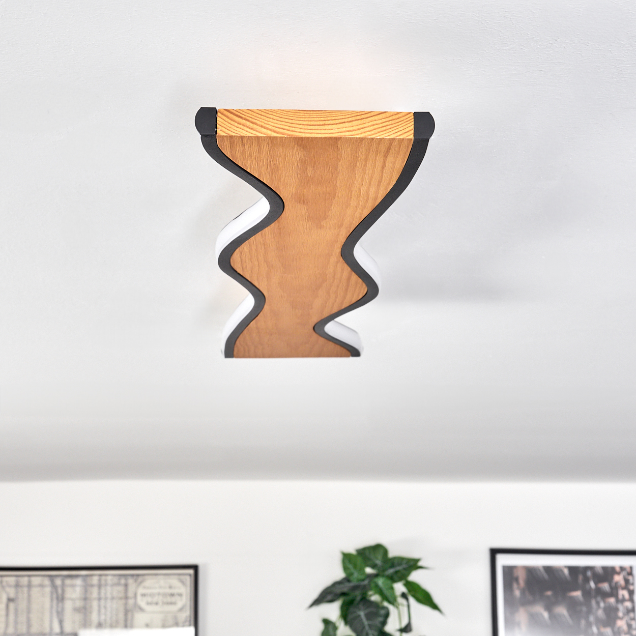 Eine hölzerne Deckenlampe mit einzigartigem Design. Sie ist braun mit schwarzen und weißen Rändern, an einer weißen Decke montiert.
