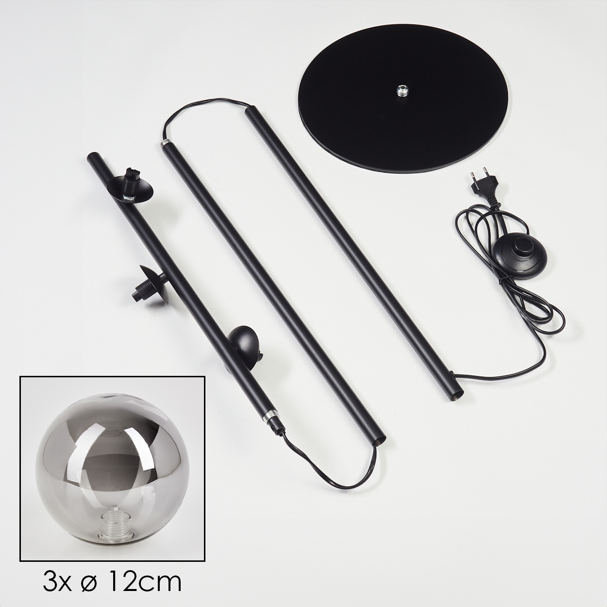 Zerlegte schwarze Stehlampe mit rundem Fuß, zwei Stangen, Glaskugel und Netzkabel mit Schalter.