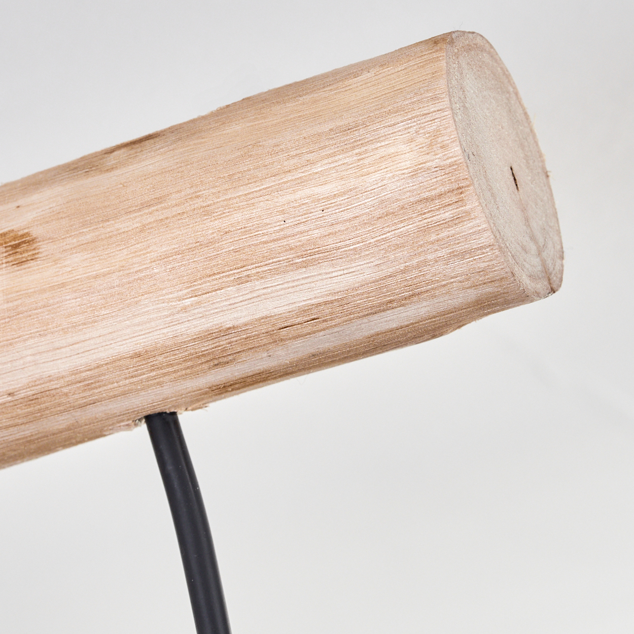 Nahaufnahme eines Holzbalkens mit schwarzem Metallträger vor weißem Hintergrund. Das Holz ist hellbraun.