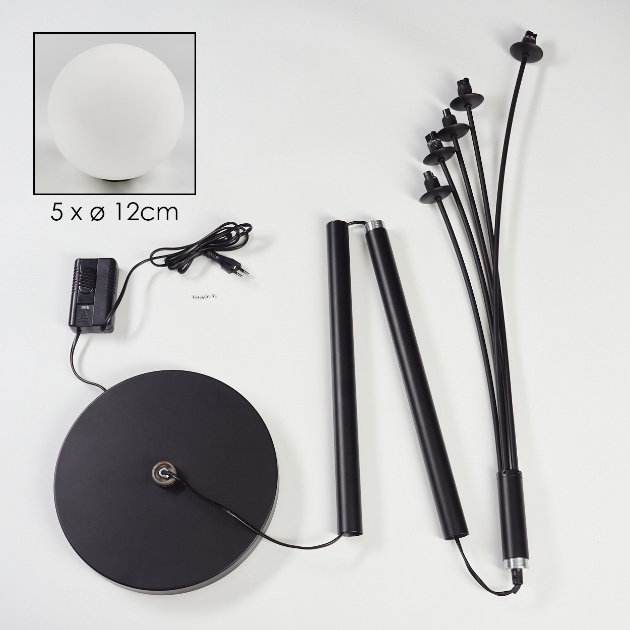 Zerlegte schwarze Stehlampe mit rundem Fuß, zwei Stangen und einer Ansammlung von Lichtstielen. Eine weiße Kugel befindet sich in einer Box.