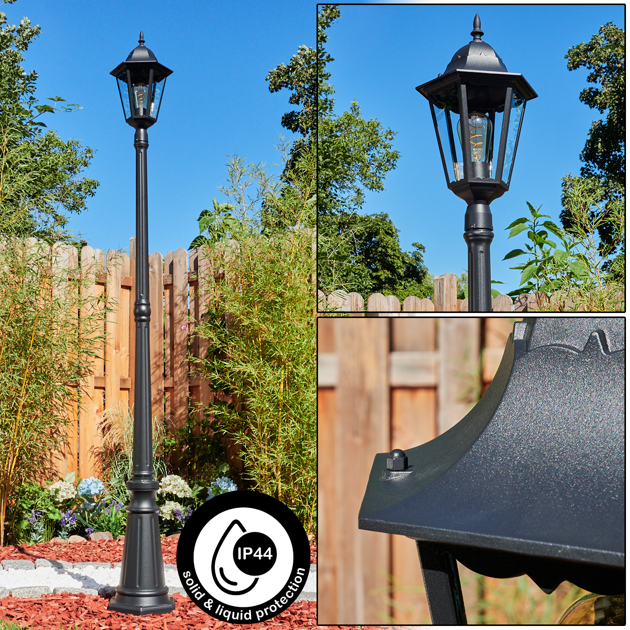 Eine schwarze Außenlaterne mit IP44-Schutz steht in einem Garten, umgeben von Grün und einem Holzzaun unter blauem Himmel.