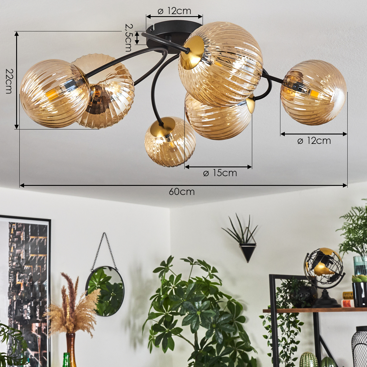 Deckenlampe mit bernsteinfarbenen Glaskugeln. Darunter Pflanzen, ein Spiegel und Dekorationsartikel.
